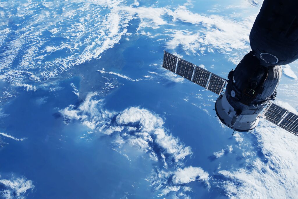 Satelliitti taivaalla kuvattuna pilvien yläpuolelta